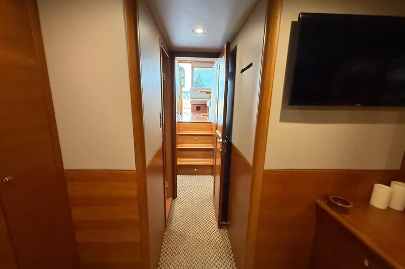  Yacht Photos Pics Hallway inside 2017 Grand Banks 44 Eastbay SX yacht, featuring wood paneling and a mounted TV.