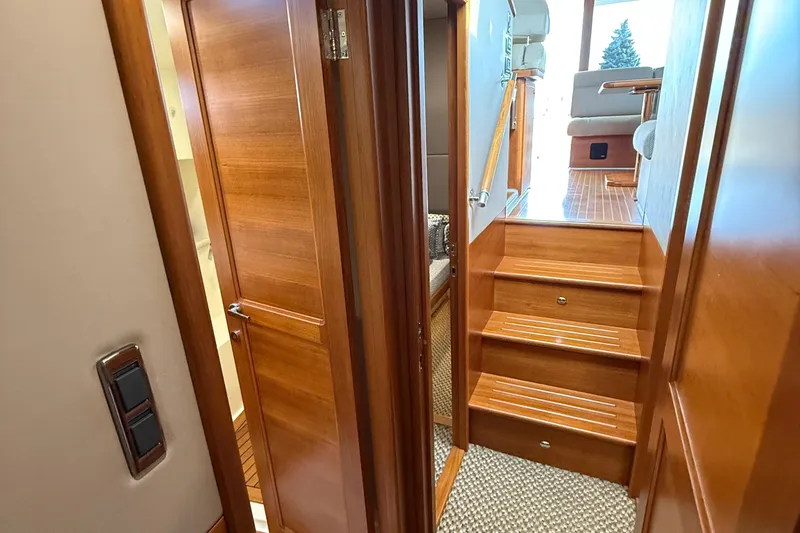  Yacht Photos Pics Luxurious interior of 2017 Grand Banks 44 Eastbay SX yacht with wooden stairs and door.