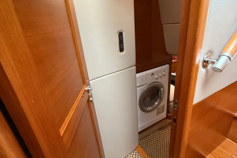  Yacht Photos Pics Laundry area inside 2017 Grand Banks 44 Eastbay SX yacht, featuring a compact washing machine.