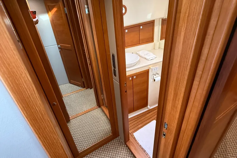  Yacht Photos Pics 2017 Grand Banks 44 Eastbay SX interior hallway with wooden cabinetry and bathroom view.