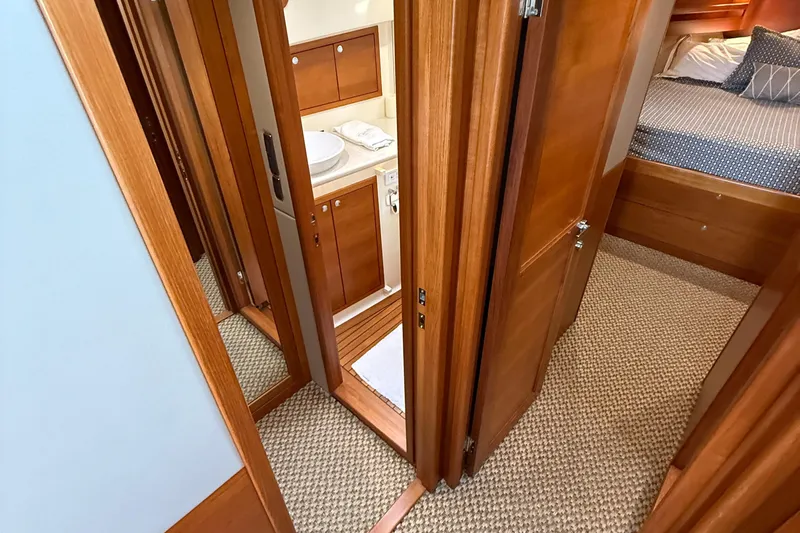  Yacht Photos Pics 2017 Grand Banks 44 Eastbay SX interior with wood finish, showing hallway, bathroom, and bedroom.