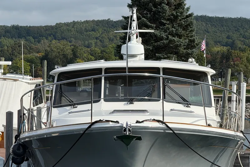  Yacht Photos Pics 2017 Grand Banks 44 Eastbay SX yacht docked, surrounded by lush greenery and calm waters.