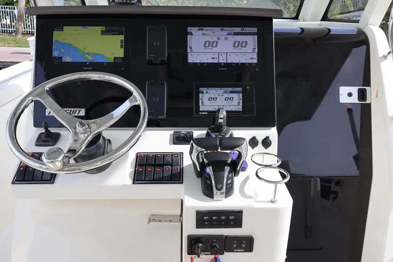  Yacht Photos Pics 2021 Pursuit S 328 Sport boat dashboard with steering wheel and navigation displays.