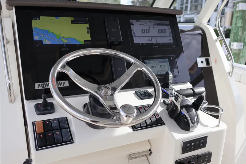  Yacht Photos Pics 2021 Pursuit S 328 Sport boat dashboard with steering wheel and navigation screens.