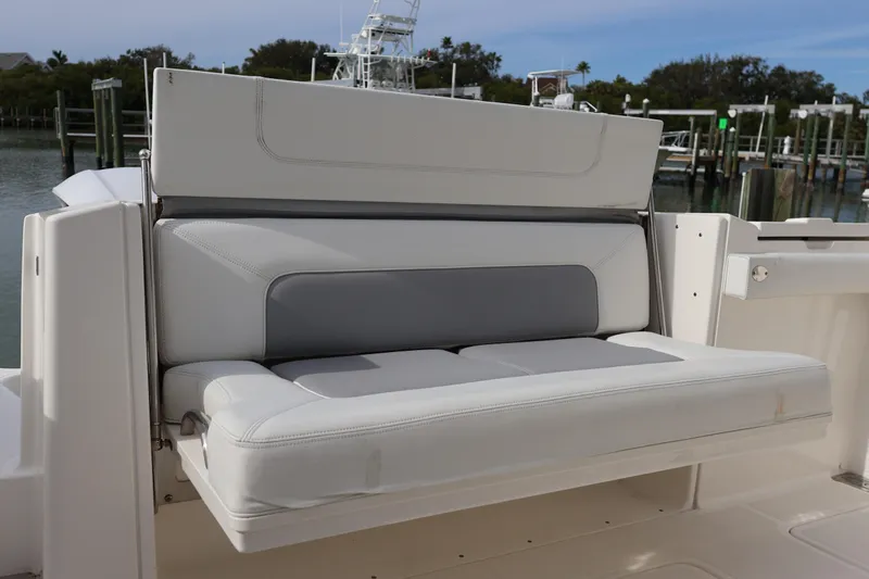  Yacht Photos Pics 2021 Pursuit S 328 Sport boat with comfortable seating, docked by the water.