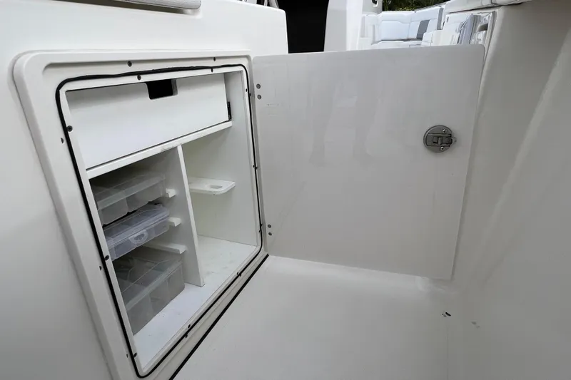  Yacht Photos Pics Open storage compartment on 2021 Pursuit S 328 Sport boat, featuring organized shelves and containers.