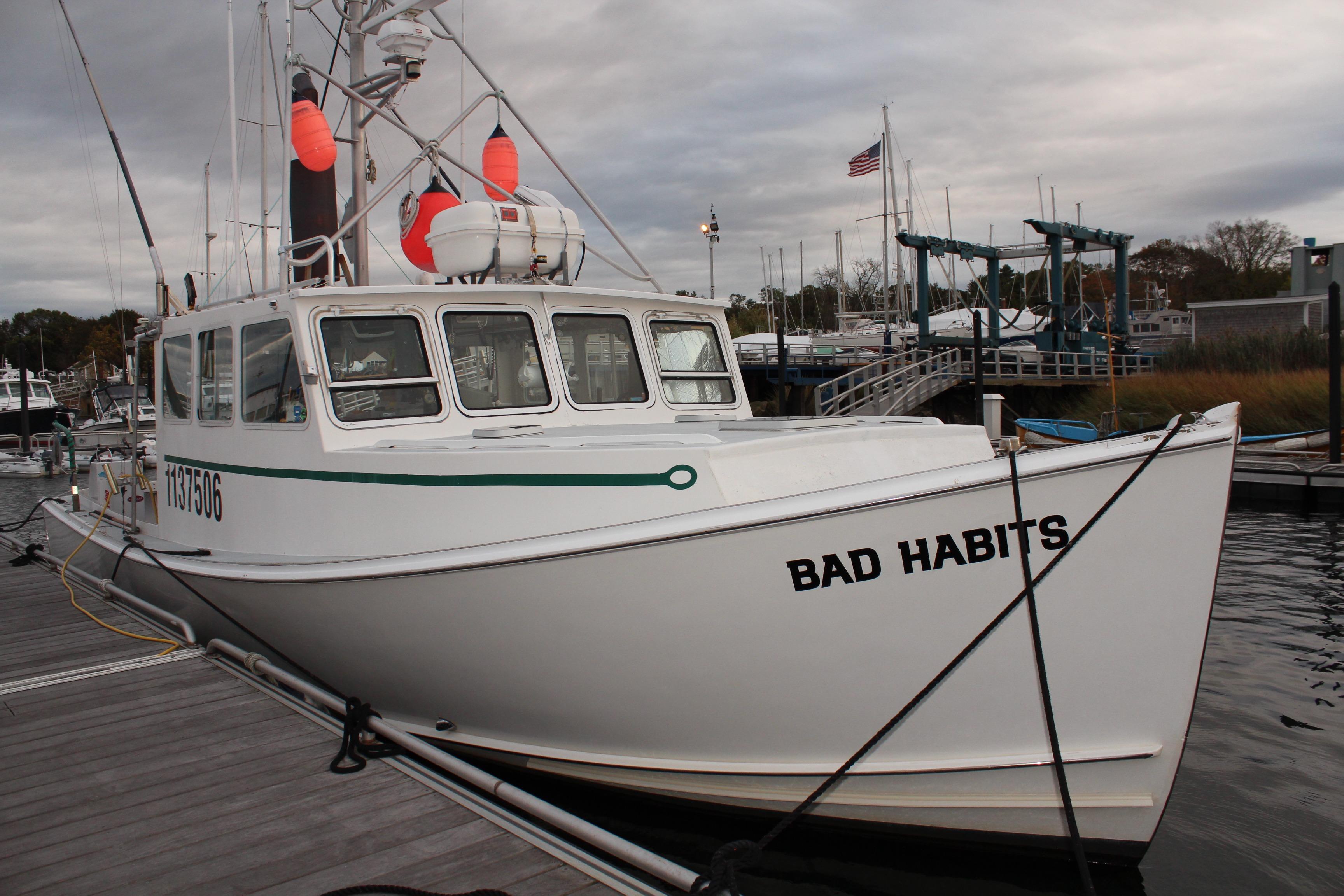 2002 Libby 38 Downeast boat "Bad Habits" docked at marina with overcast sky.