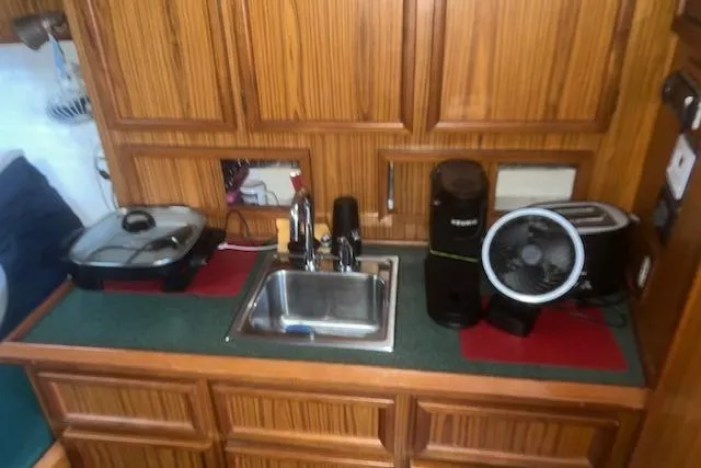 Bad Habits Yacht Photos Pics Compact kitchen area in a 2002 Libby 38 Downeast boat with sink and appliances.