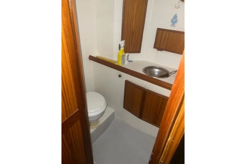 Bad Habits Yacht Photos Pics Compact bathroom in 2002 Libby 38 Downeast boat with wooden cabinets and stainless steel sink.