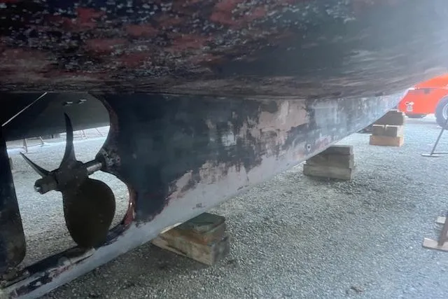 Bad Habits Yacht Photos Pics 2002 Libby 38 Downeast boat hull on blocks, showing propeller and weathered paint.