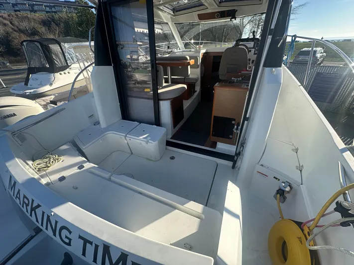 Marking Time Yacht Photos Pics 2016 Jeanneau Merry Fisher 855 boat interior with seating and helm, docked outdoors.
