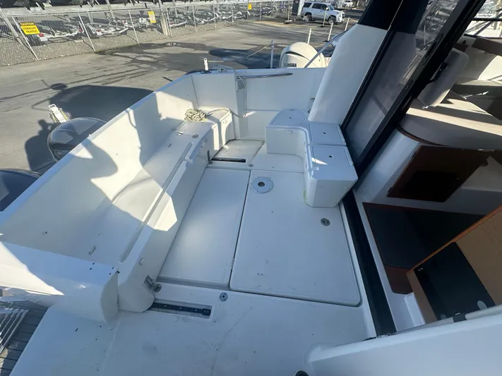 Marking Time Yacht Photos Pics 2016 Jeanneau Merry Fisher 855 boat deck with seating and storage compartments.