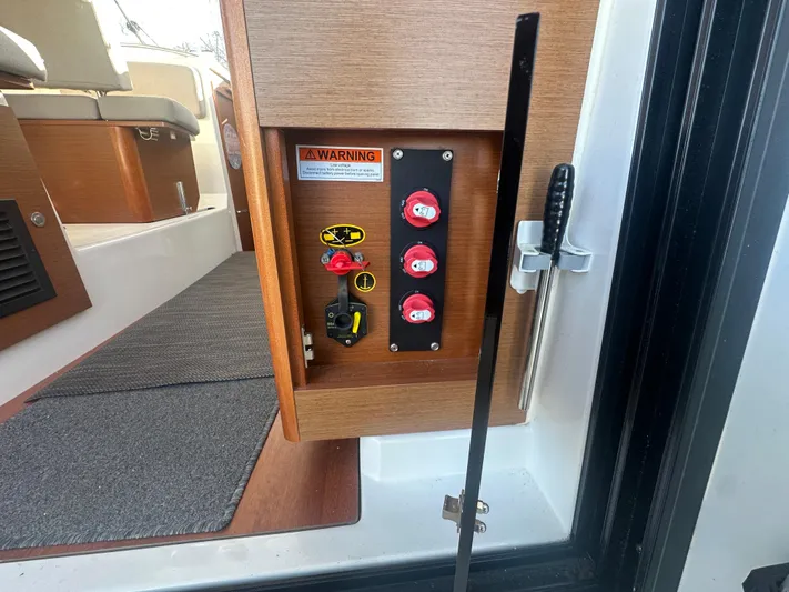Marking Time Yacht Photos Pics Control panel on 2016 Jeanneau Merry Fisher 855 boat, featuring switches and warning label.