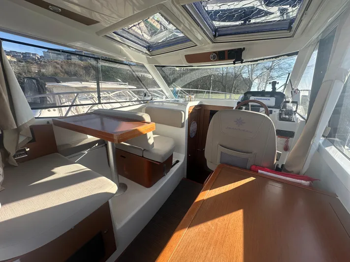 Marking Time Yacht Photos Pics Interior of 2016 Jeanneau Merry Fisher 855 boat with seating and navigation area.