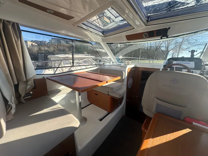 Marking Time Yacht Photos Pics Interior of 2016 Jeanneau Merry Fisher 855 boat with seating and table.
