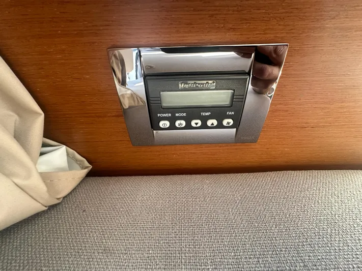 Marking Time Yacht Photos Pics Control panel on Jeanneau Merry Fisher 855, 2016 model, with wood and fabric surroundings.