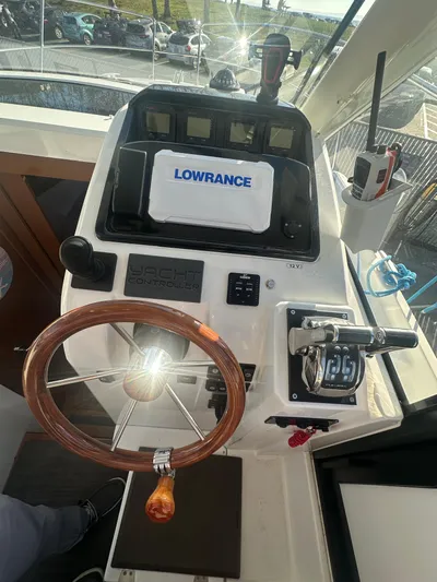 Marking Time Yacht Photos Pics Helm of 2016 Jeanneau Merry Fisher 855 with Lowrance navigation system and wooden steering wheel.