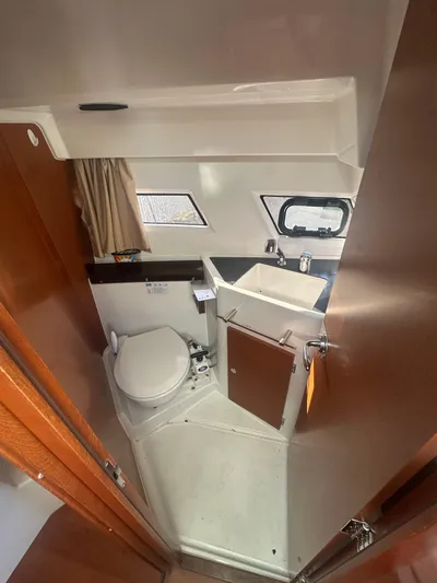 Marking Time Yacht Photos Pics 2016 Jeanneau Merry Fisher 855 bathroom with sink, toilet, and window.