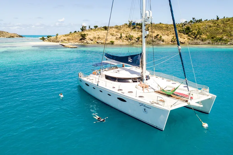 Pono Yacht Photos Pics Luxury 2005 Fountaine Pajot FP Eleuthera 60 catamaran anchored in turquoise waters.