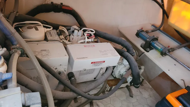 Pono Yacht Photos Pics Engine room of 2005 Fountaine Pajot FP Eleuthera 60 catamaran with visible machinery and hoses.