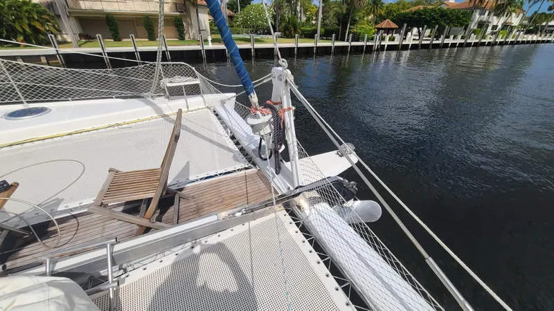 Pono Yacht Photos Pics 2005 Fountaine Pajot FP Eleuthera 60 catamaran deck with netting and wooden chairs.