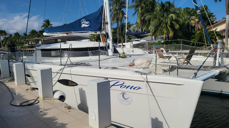 Pono Yacht Photos Pics 2005 Fountaine Pajot FP Eleuthera 60 catamaran docked, surrounded by tropical palm trees.