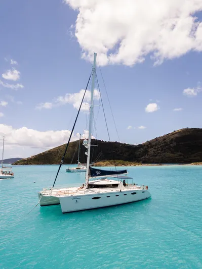 Pono Yacht Photos Pics 2005 Fountaine Pajot FP Eleuthera 60 catamaran sailing in turquoise waters, clear sky.