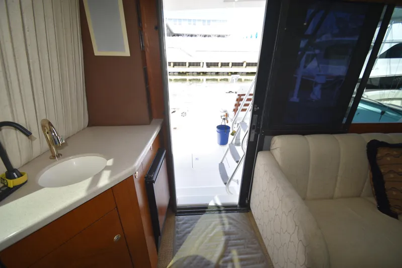 Whaler Yacht Photos Pics Interior view of 1997 Ocean 48 Convertible yacht, featuring a sink, sofa, and open door to deck.