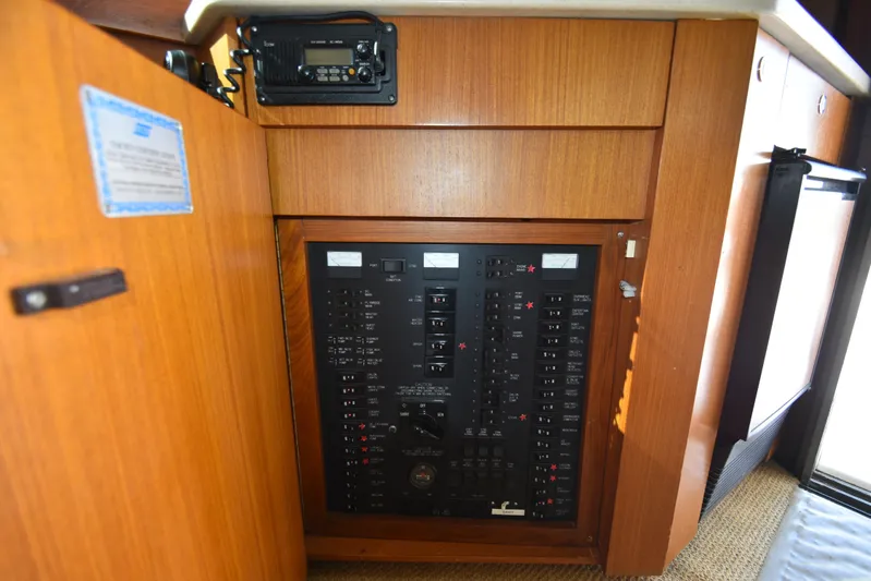 Whaler Yacht Photos Pics Electrical panel inside a 1997 Ocean 48 Convertible yacht, featuring wooden cabinetry.