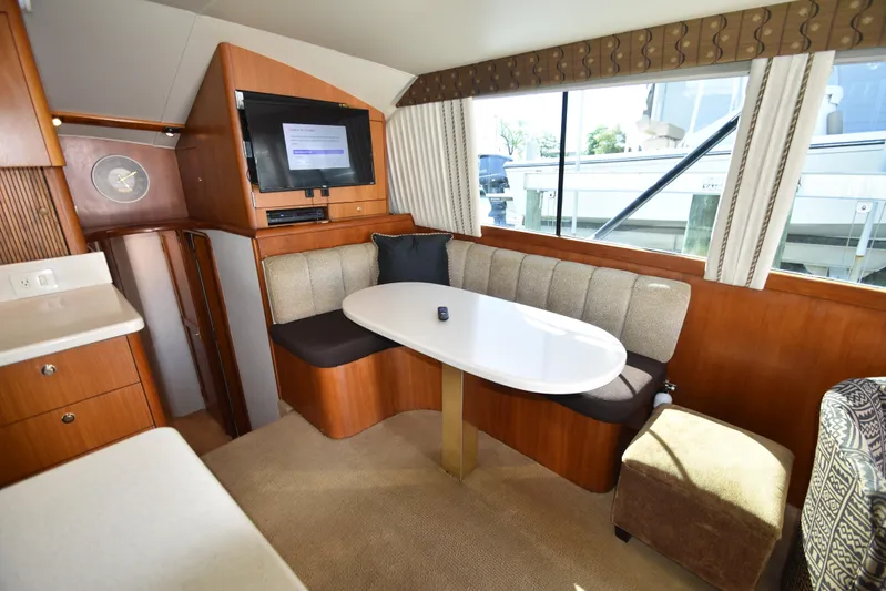 Whaler Yacht Photos Pics Luxurious interior of 1997 Ocean 48 Convertible yacht with dining area and TV.