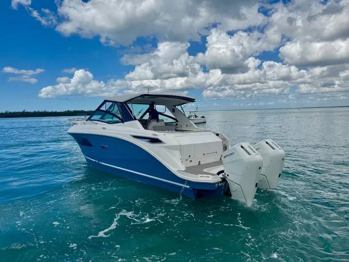  Yacht Photos Pics 2025 Sea Ray Sundancer 320 Outboard on calm waters under blue skies.