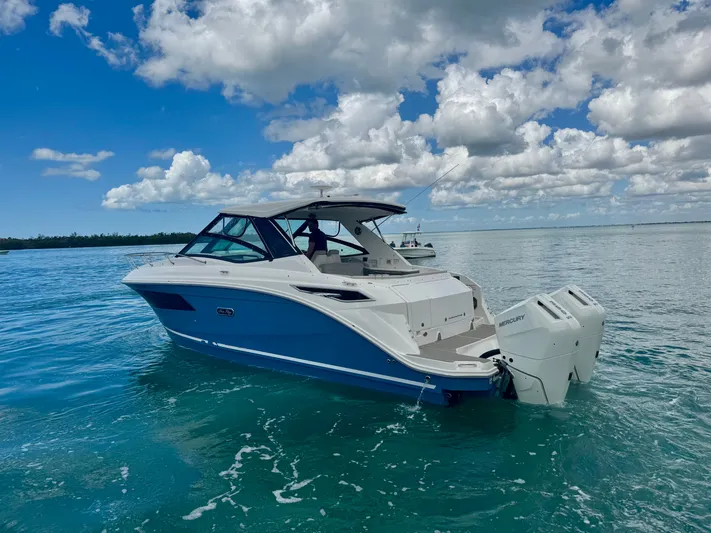  Yacht Photos Pics 2025 Sea Ray Sundancer 320 Outboard on calm waters under blue sky.