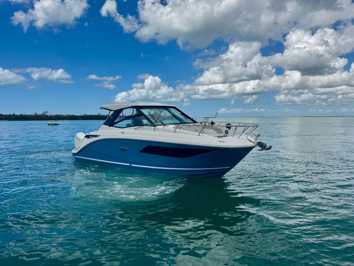  Yacht Photos Pics 2025 Sea Ray Sundancer 320 Outboard on calm water under blue sky.