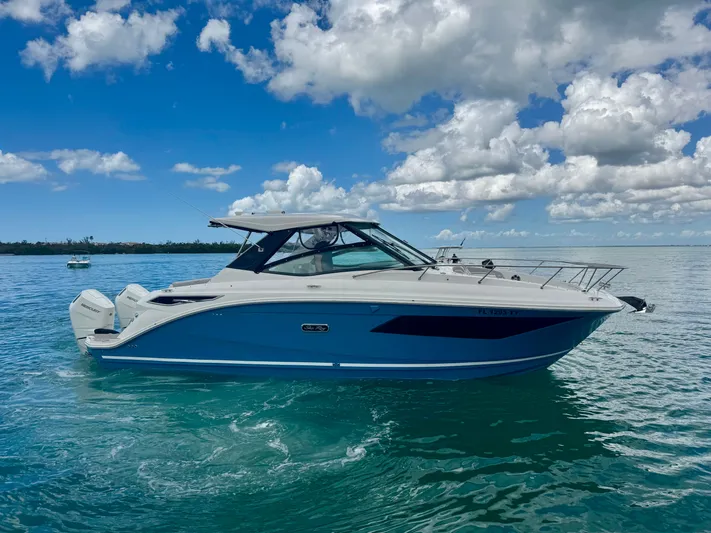 Yacht Photos Pics 2025 Sea Ray Sundancer 320 Outboard on calm water under blue sky.