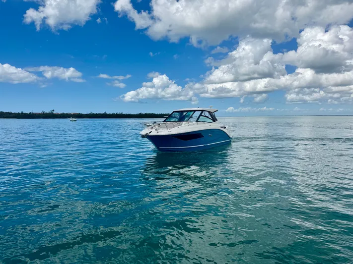  Yacht Photos Pics 2025 Sea Ray Sundancer 320 Outboard on calm water under blue sky.