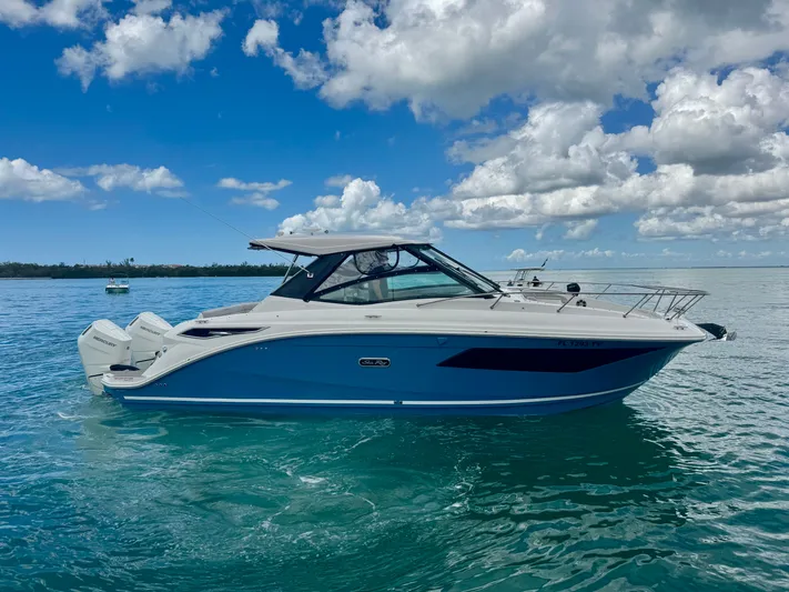  Yacht Photos Pics 2025 Sea Ray Sundancer 320 Outboard on calm water under blue sky.