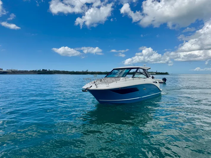  Yacht Photos Pics 2025 Sea Ray Sundancer 320 Outboard on calm water under blue sky.