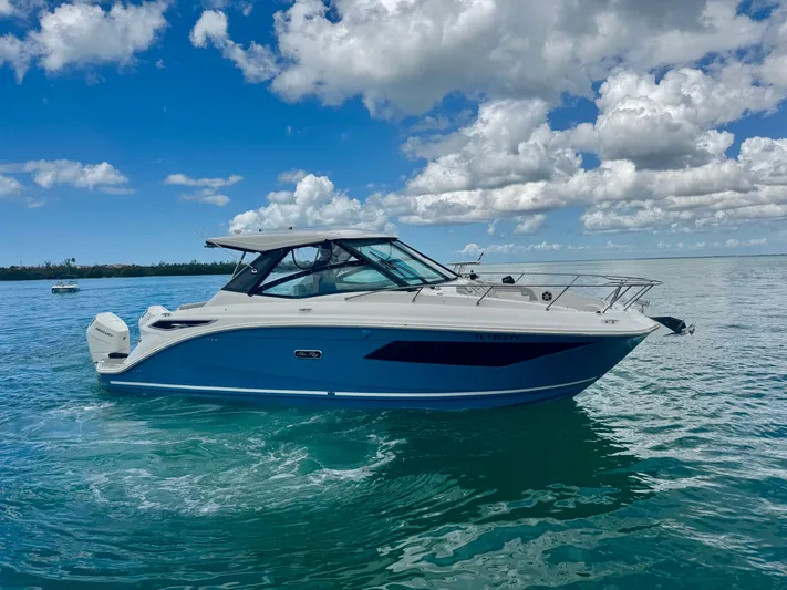  Yacht Photos Pics 2025 Sea Ray Sundancer 320 Outboard on calm water under blue sky.
