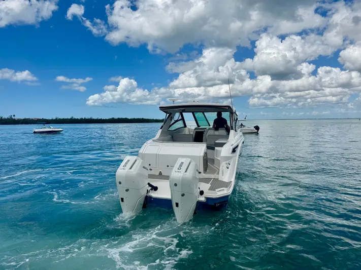  Yacht Photos Pics 2025 Sea Ray Sundancer 320 Outboard on calm waters under blue sky.