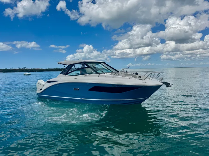  Yacht Photos Pics 2025 Sea Ray Sundancer 320 Outboard on calm water under blue sky.