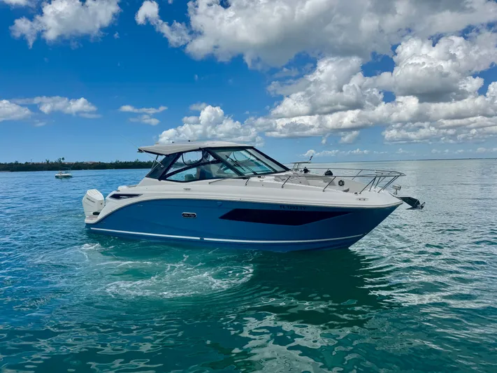  Yacht Photos Pics 2025 Sea Ray Sundancer 320 Outboard on calm water under blue sky.