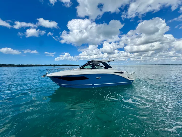  Yacht Photos Pics 2025 Sea Ray Sundancer 320 Outboard on calm water under blue sky.