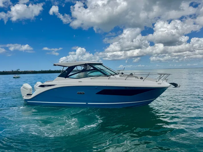  Yacht Photos Pics 2025 Sea Ray Sundancer 320 Outboard on calm water under blue sky.