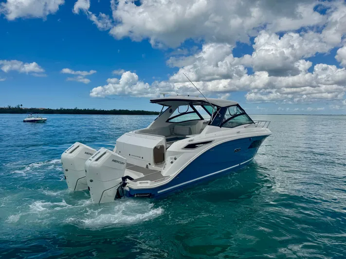  Yacht Photos Pics 2025 Sea Ray Sundancer 320 Outboard on calm waters under blue sky.