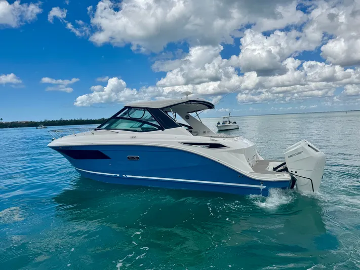  Yacht Photos Pics 2025 Sea Ray Sundancer 320 Outboard on calm water under blue sky.