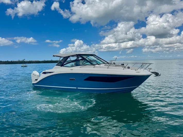  Yacht Photos Pics 2025 Sea Ray Sundancer 320 Outboard on calm water under blue sky.