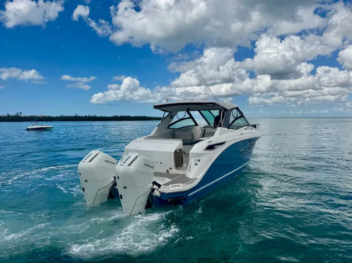  Yacht Photos Pics 2025 Sea Ray Sundancer 320 Outboard on calm waters under blue sky.
