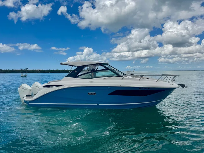  Yacht Photos Pics 2025 Sea Ray Sundancer 320 Outboard on calm water under blue sky.