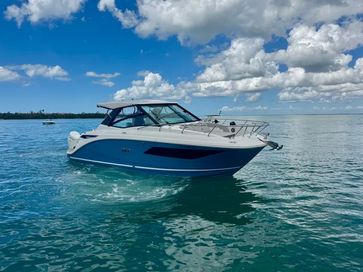  Yacht Photos Pics 2025 Sea Ray Sundancer 320 Outboard on calm water under blue sky.