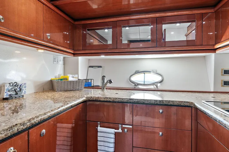 Blue Steel Yacht Photos Pics Luxurious kitchen interior of 1998 Sunseeker Predator 80 yacht with wooden cabinets and granite countertops.